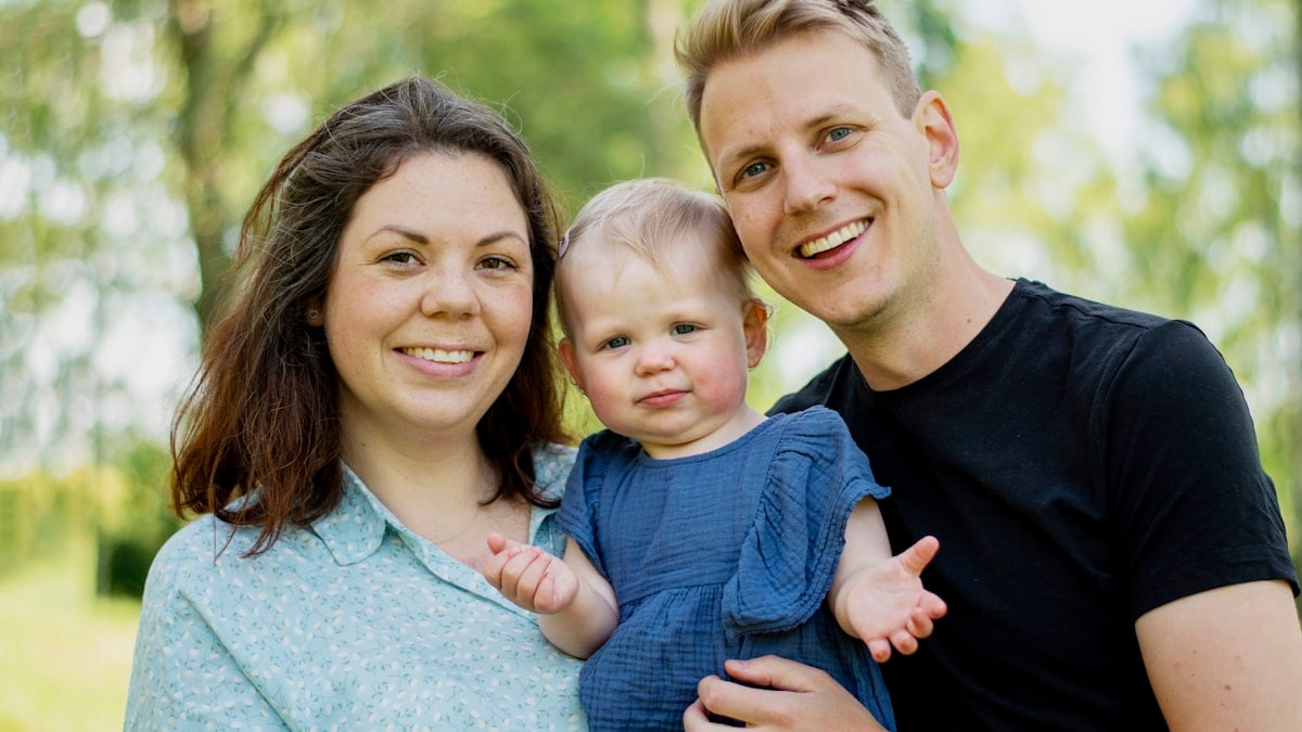 a man and woman holding a baby
